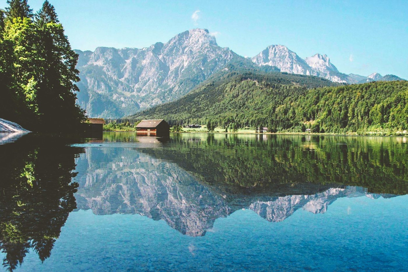 Bergsee in Österreich mit Bootshaus und Spiegelung der Berge